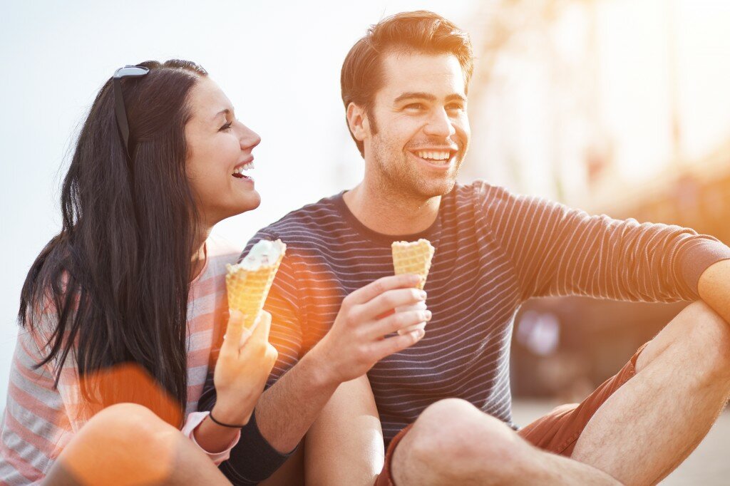 romantic couple eating ice cream at park