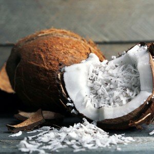 Coconut shavings in coconut on wooden background