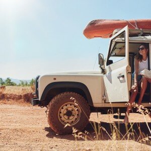 Young Couple On Road Trip Reading Map For Directions